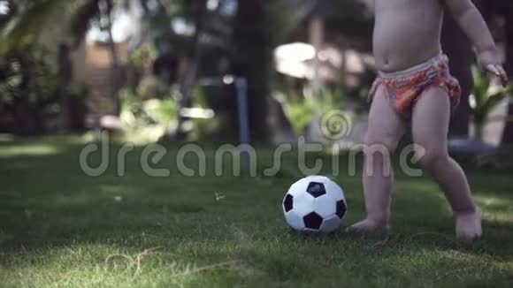 一个两岁的男孩喜欢在公园里踢足球跑步和踢球视频的预览图