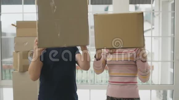 快乐的一对夫妇在一间新房子里慢动作地玩盒子视频的预览图