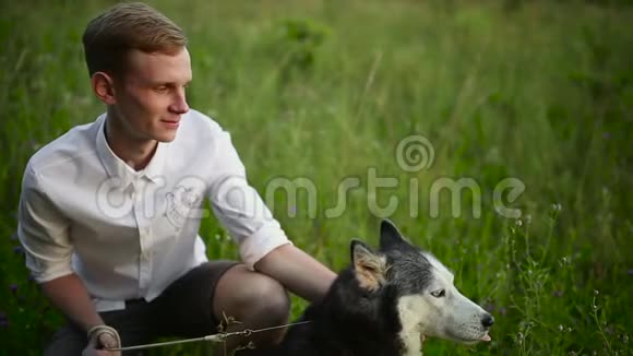 人和狗西伯利亚哈士奇概念亚洲年轻人带着他的狗在草地上视频的预览图