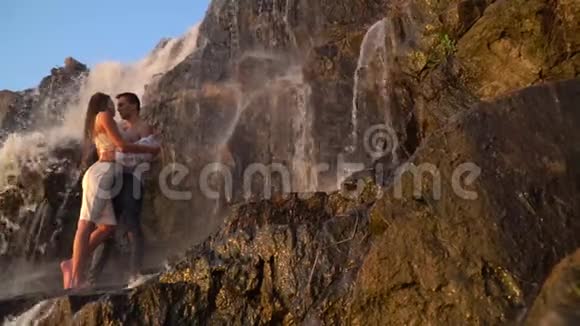 一对相爱的人站在瀑布下接吻视频的预览图