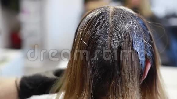 理发师将染发剂涂在头发的特写背面视频的预览图
