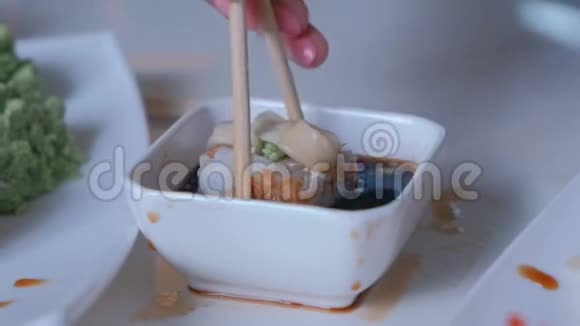 女人吃肉卷放入酱油卷学习用木棍吃饭手特写视频的预览图