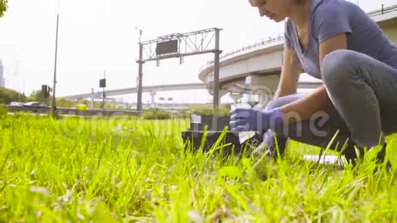 女生态学家在高速公路附近采集土壤样本视频的预览图