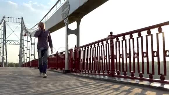 年轻人在桥上呼唤某人用是的姿态开始快乐地跳跃视频的预览图