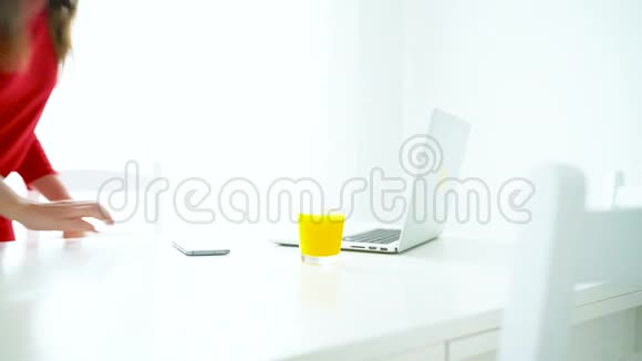 微笑的女人在白色家庭办公室查看笔记本电脑上的电子邮件视频的预览图