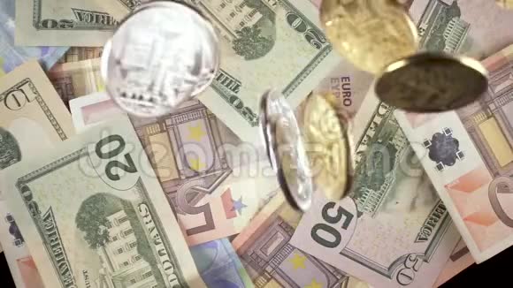 慢动作硬币落在现金欧元和美元上视频的预览图