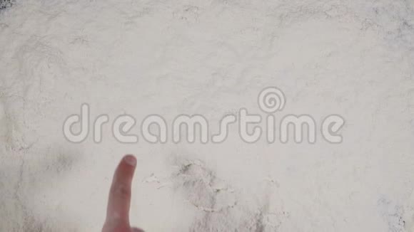 手指在白色面粉背景上画着滑稽的微笑顶视图4k视频的预览图