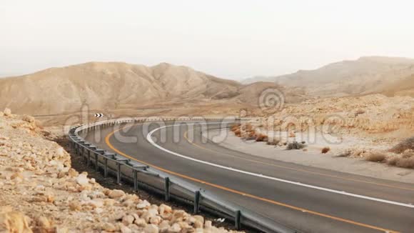以色列沙漠空沥青路曲线景观4K在古老的内盖夫沙漠风景道现代交通视频的预览图