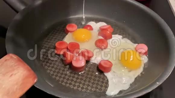 一个男人用香肠准备炒鸡蛋视频的预览图