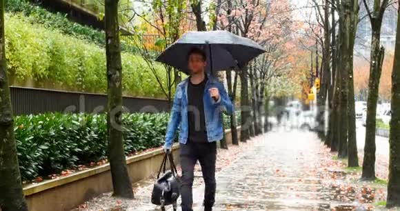 男人撑着伞走在街上视频的预览图