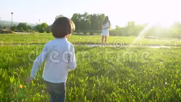家庭在户外快乐母子拥抱在太阳日享受大自然的夏天妈妈和孩子可爱的男孩玩得开心视频的预览图