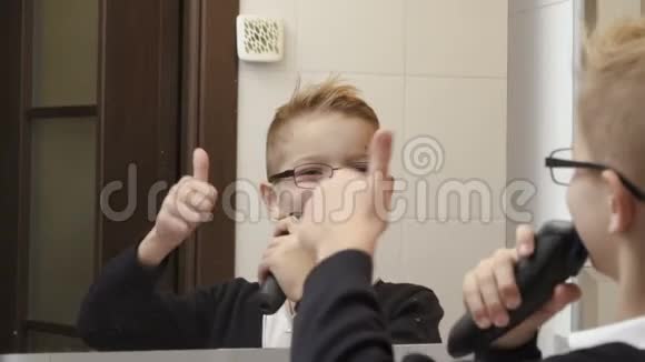 小男孩模仿用电动剃须刀刮脸视频的预览图
