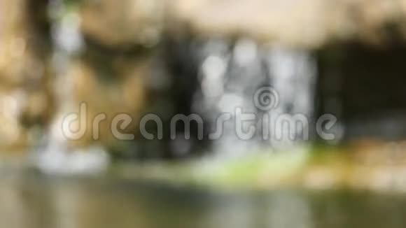 在阳光下瀑布的离焦在水面上反射视频慢动作视频的预览图