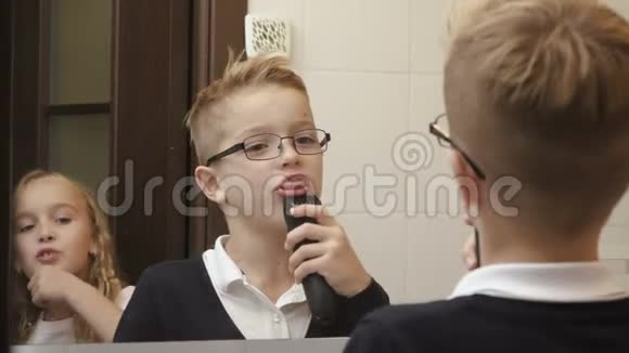 可爱的小男孩模仿用电动剃须刀刮胡子视频的预览图