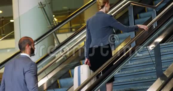 商人和女人带着行李爬上楼梯视频的预览图