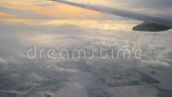 透过肮脏的飞机窗户观看部分机翼和日落多云的天空视频的预览图