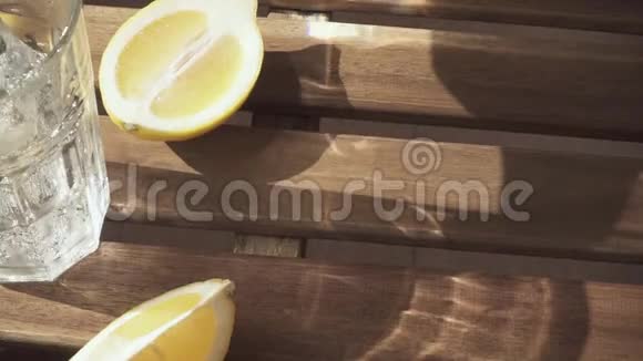 柠檬片放在桌子上水被倒入一个玻璃慢速运动视频的预览图