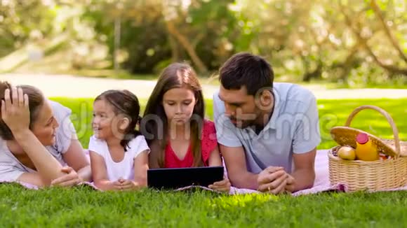 夏季公园野餐时带平板电脑的家庭视频的预览图