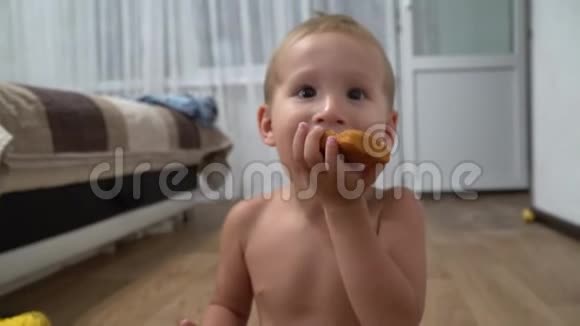 一个小男孩坐在房间里吃着美味的蛋糕视频的预览图