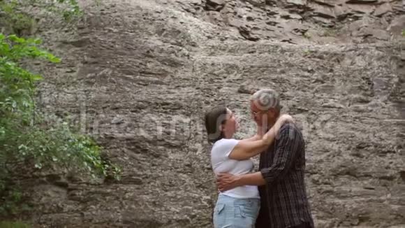 一对老夫妇在岩石的背景下拥抱视频的预览图