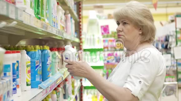 老年妇女在超市选择化学清洁用品在商店里购物高级女性视频的预览图