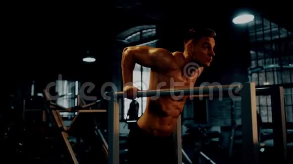 在黑暗的健身房里做肱三头肌的运动视频的预览图