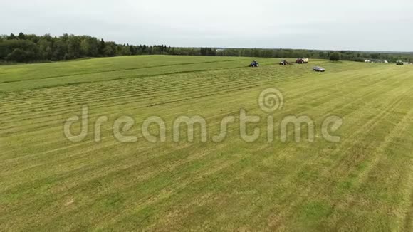 相机显示了大的绿色和灰色的田野上面有正在运行的拖拉机和汽车视频的预览图