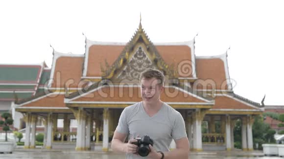 一位年轻英俊的观光客对着曼谷的佛寺拍照视频的预览图