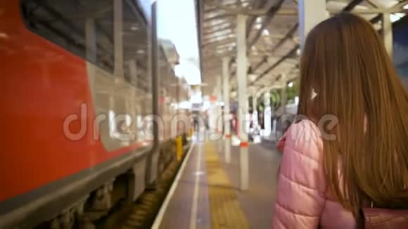 年轻漂亮的女人沿着火车沿着火车站走视频的预览图