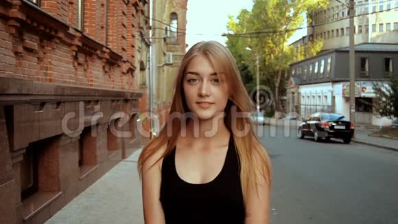 站在街上的金发美女看着镜头微笑着视频的预览图