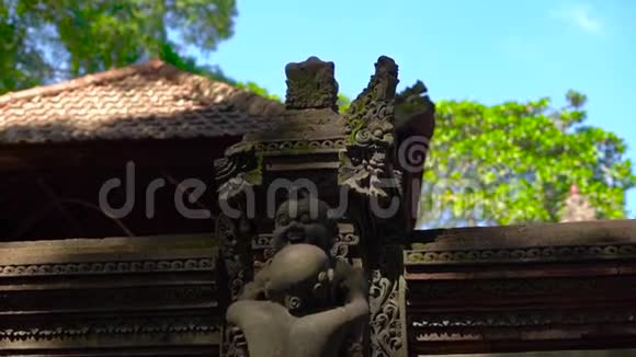一座用石雕覆盖的猴子森林中的庙宇的墙壁和雕像的缓慢移动的稳定镜头视频的预览图