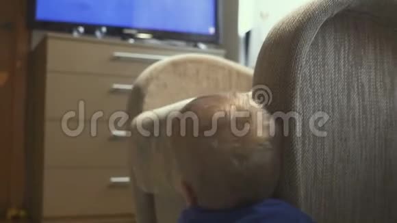 一岁的孩子看电视娃娃镜头小男孩在房间里电视上看卡通视频的预览图