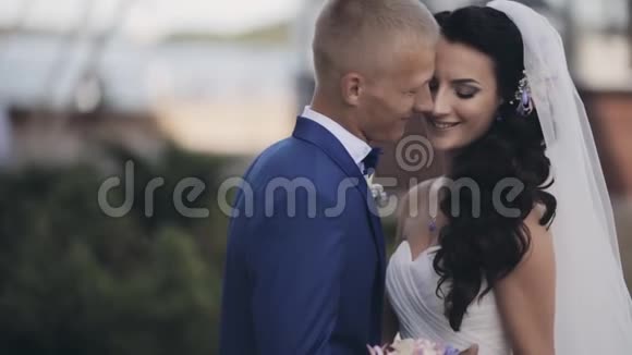 快乐的新婚夫妇在大自然中拥抱外面美丽的新郎和新娘接吻一个人温柔地在一起视频的预览图