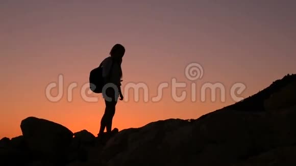 攀登一座山的女游客剪影视频的预览图