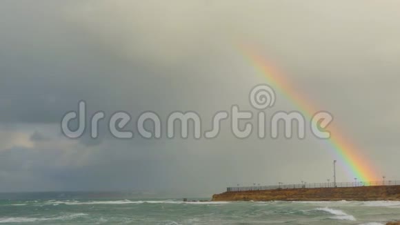 暴风雨过后的彩虹从城市海滨上空升起视频的预览图