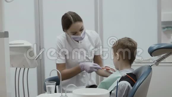 牙医教小男孩如何用牙刷清洁牙齿模型视频的预览图