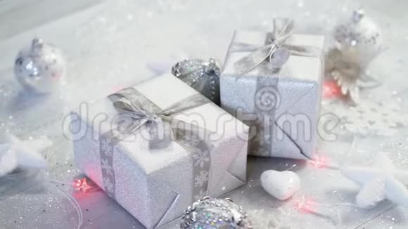 圣诞桌装饰两份银色礼物雪片和白色星星的灯光视频的预览图