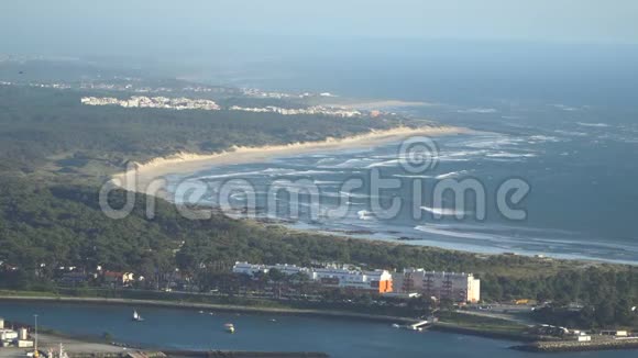 一个美丽的沙滩的顶部景色与蓝色的波浪滚动到海岸一些岩石存在葡萄牙视频的预览图