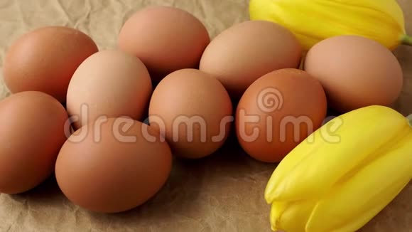 棕色包装纸上的新鲜鸡蛋鸡蛋和郁金香视频的预览图