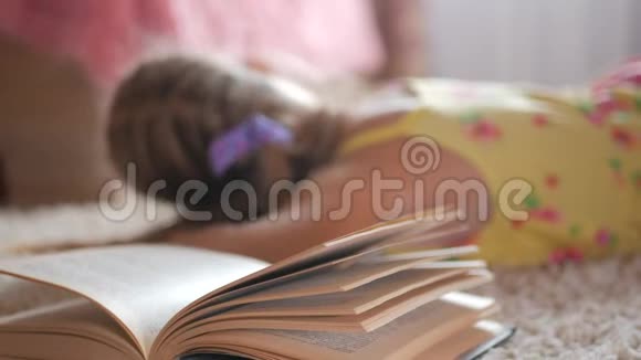 画像悲伤的女学生不想读书读书一个可爱的金发女孩睡在书上她累了视频的预览图