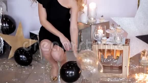 一个穿着黑色衣服的有魅力的女孩扔出气球节日气氛视频的预览图