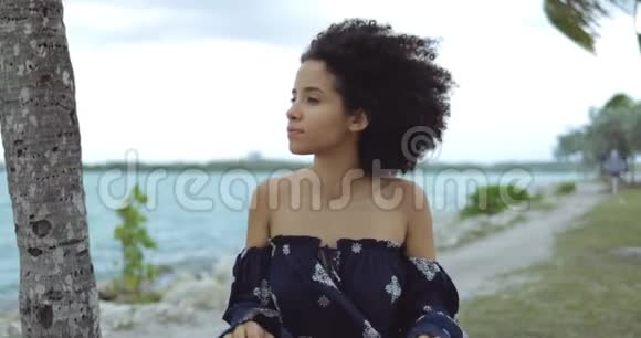 在海岸线上享受风的女人视频的预览图
