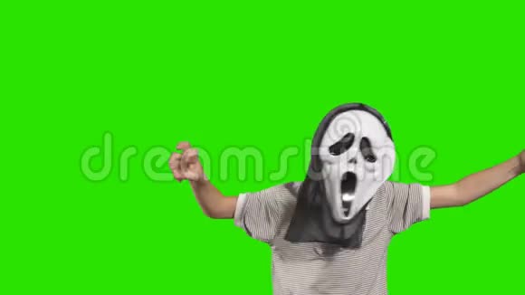 戴着可怕面具的男孩在绿色背景下吓人视频的预览图