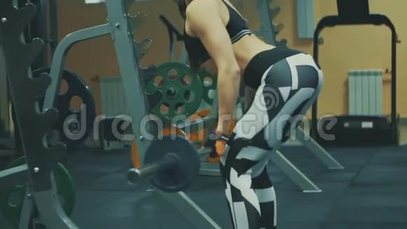 运动健身馆里用杠铃伸展肌肉的美女视频的预览图