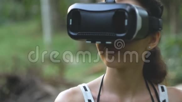 女人用虚拟现实眼镜在丛林中慢动作轨道射击视频的预览图