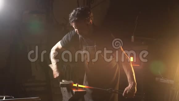 一个忙于努力工作的人的肖像史密斯在一个有熔融金属预制件的车间工作慢动作视频的预览图