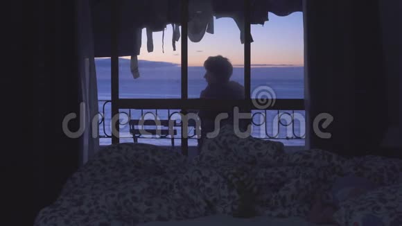带海景的酒店阳台一位年轻女子看日出视频的预览图