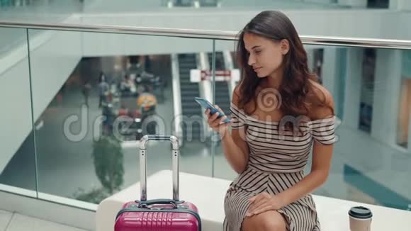 微笑女性使用智能手机语音识别的肖像带行李的白种人青年女孩视频的预览图