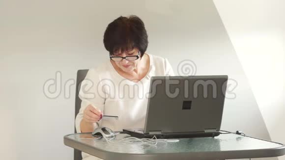 中年妇女在网上商店付款互联网购物为退休人员提供在线服务视频的预览图