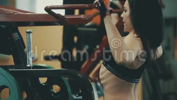 在健身馆里漂亮女孩在健身器里锻炼背部肌肉视频的预览图